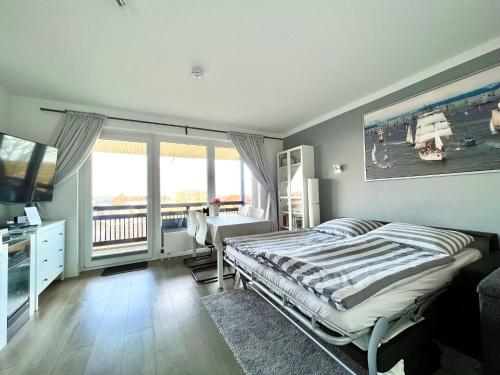 a bedroom with a bed and a desk and window at Ostsee-Fördeblick in Laboe