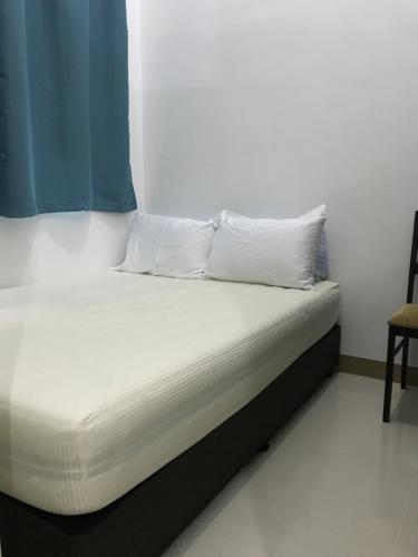 a bed with white sheets and pillows in a room at South Residences staycation in Manila