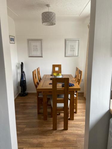 a dining room with a wooden table and chairs at Cumberland Avenue prenton Wirral 3bed detached house with a lovely view looking out on to a field from the rear close to all amenities in Birkenhead