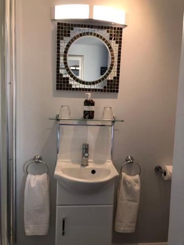W łazience znajduje się umywalka i lustro. w obiekcie High Ways House w mieście Woolacombe