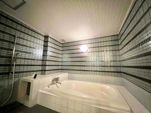 a bathroom with a bath tub with a sink at SKY Bali Style Beppu, Resort Love Hotel in Beppu