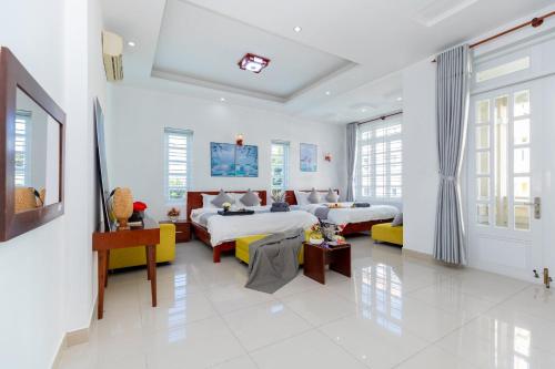 ブンタウにあるLuxury Villa Bãi Sau Near Beachのベッド2台とソファが備わる広い白い客室です。