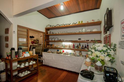 een winkel met een tafel en bloemen in een kamer bij Águas do Pantanal Inn Pousada in Miranda