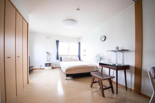 a bedroom with a bed and a table and a chair at Sumiyoshi House Room B in Otaru