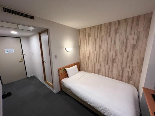 - une petite chambre avec un lit blanc et une porte dans l'établissement Kitami Daiichi Hotel - Vacation STAY 45969v, à Kitami