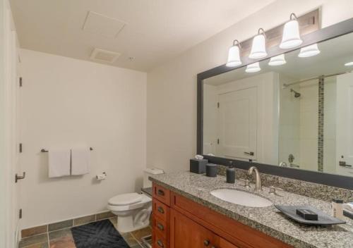 W łazience znajduje się umywalka, toaleta i lustro. w obiekcie Luxury Ski In, Ski Out 1 Bedroom Colorado Resort Vacation Rental In The Heart Of Snowmass Base Village w Aspen