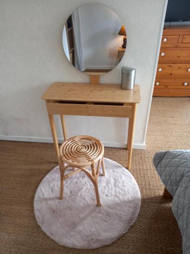 une petite table en bois avec un miroir et un tabouret dans l'établissement Au bord du Vilpion, à Marle-et-Behaine