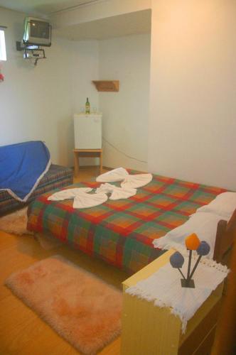 a bedroom with a bed with a plaid blanket at Pousada Manu in Canela