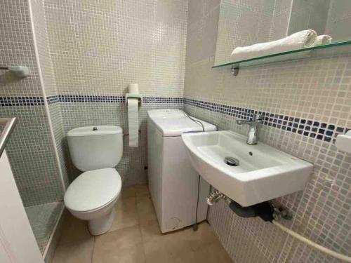 a bathroom with a toilet and a sink at Calan Blanes con piscina in Ciutadella