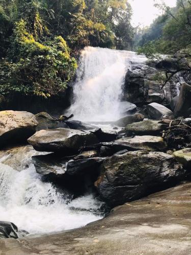 a waterfall in the middle of a river with rocks at Motho Homestay โมโทโฮมสเตย์ in Chom Thong