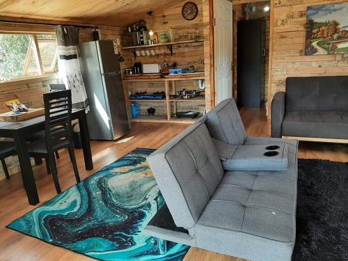 uma sala de estar com um sofá e uma mesa em Diamond Vault Rustic Mountain Cabins em Hogsback