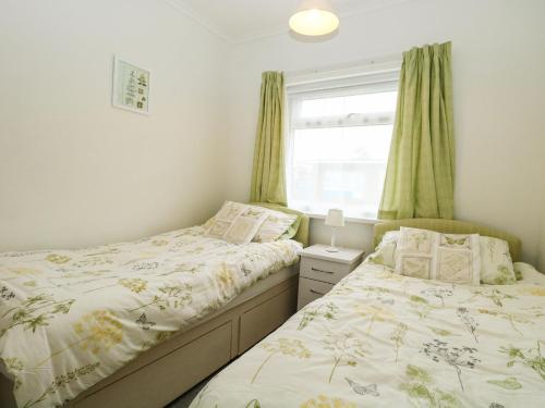 two twin beds in a bedroom with a window at 21 Siesta Mar in Mundesley