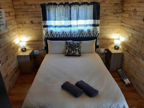 uma cama num quarto com duas almofadas em Diamond Vault Rustic Mountain Cabins em Hogsback