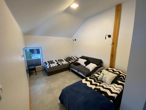 Cette chambre comprend 2 lits et un canapé. dans l'établissement Apartament, à Oboźna Droga Masłów