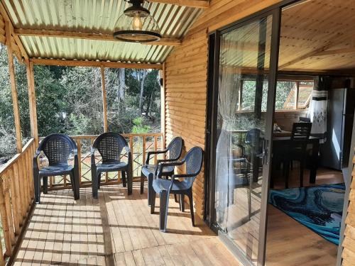 a screened in porch with chairs and a table at Diamond Vault Rustic Mountain Cabins in Hogsback