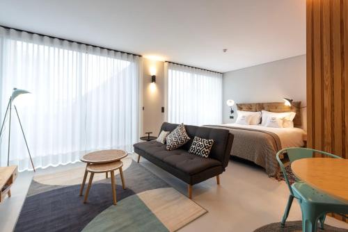 a hotel room with a bed and a couch and a table at Blau 1911 in Porto