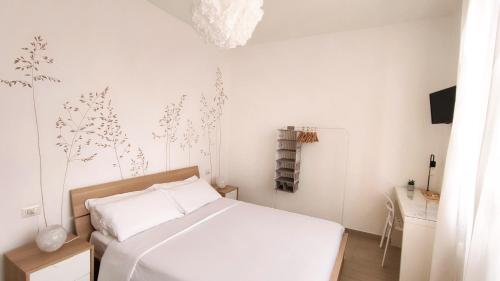 1 dormitorio con cama blanca y pared blanca en B&B Le Albarelle en Alba
