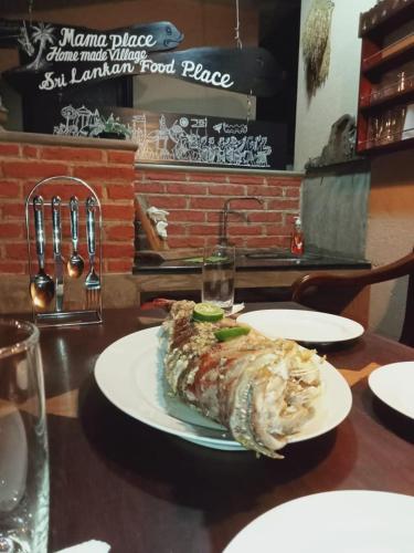 a fish on a plate on a table at Mama Villa Hikkaduwa in Hikkaduwa