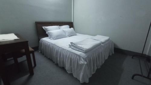 1 dormitorio con 1 cama con sábanas y almohadas blancas en Enjoy Mekong Hostel, en Can Tho