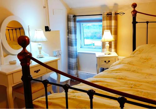 una camera con letto e finestra di Fisherman's Cottage - The Ultimate Romantic Lakeside Cottage just a few steps from the Beach! Relax with a glass of wine & Snuggle up to the Cosy Log Burner at the BEST Location in Mablethorpe! It's Pet Friendly too! a Mablethorpe