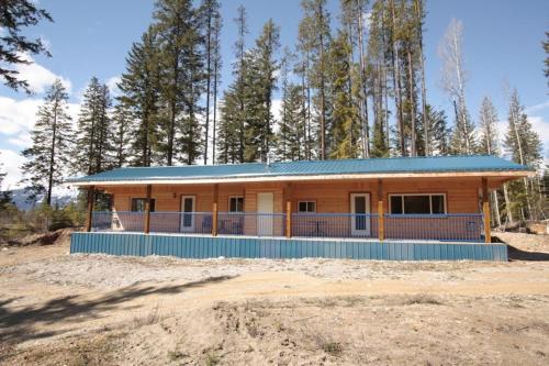 a house with a blue roof in a field at Glenogle Mountain Lodge and Spa in Golden