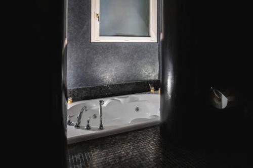 a bathroom with a bath tub and a mirror at Villa MERAVIGLIA, heated pool, 16 km from the sea in Ascoli Piceno