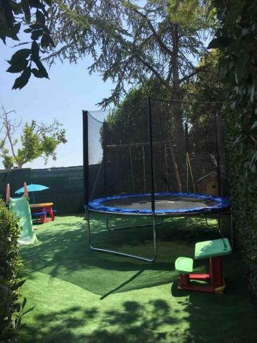 a trampoline in a yard with two chairs at Villa MERAVIGLIA, heated pool, 16 km from the sea in Ascoli Piceno