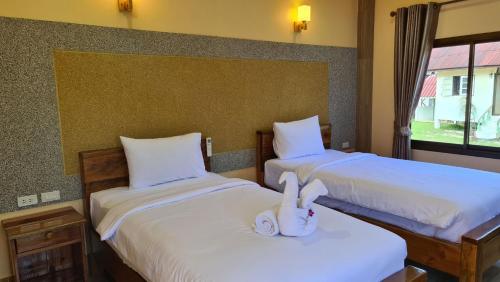 a bedroom with two beds with towels on them at Thongplu Beach Resort Samui in Ban Thong Phlu