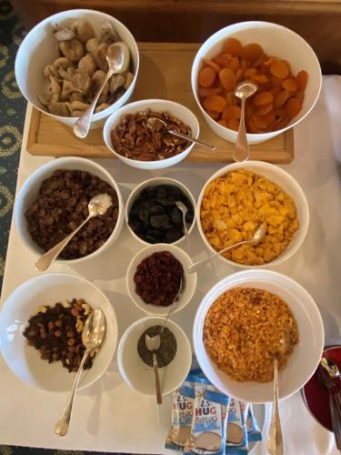 a table topped with bowls of different types of food at Hotel Beau Rivage Weggis in Weggis