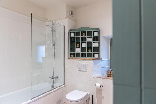 a bathroom with a toilet and a glass shower at Hotel Monells Summum in Monells