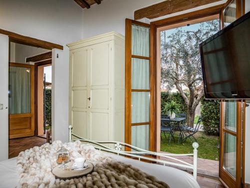 a living room with a tv and a large window at Valle del Metauro Country House in Montemaggiore al Metauro