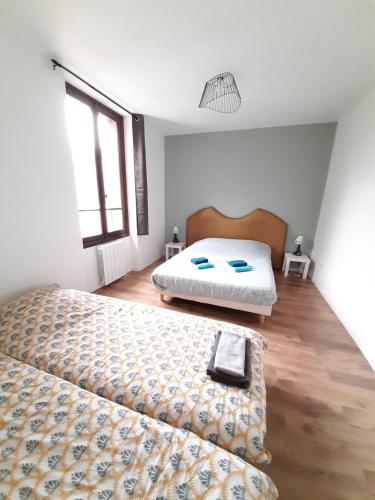 1 dormitorio con 2 camas y suelo de madera en Résidence du Houx - 4 (Astérix, Aéroport CDG, Chantilly, Parc expos...) en Survilliers