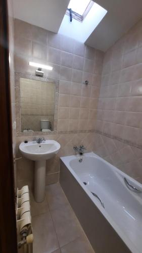 uma casa de banho com um lavatório e uma banheira e um lavatório em Casa rural La Casina em Sariego