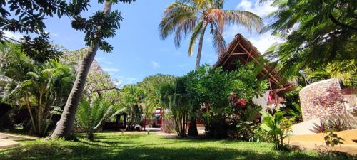 a garden with palm trees and a building at Lions' Luxury Eco Resort & Spa in Malindi