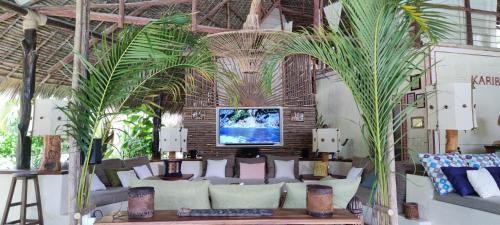 a living room with a couch and palm trees at Lions' Luxury Eco Resort & Spa in Malindi