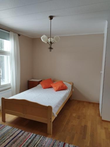 a bedroom with a bed with two orange pillows on it at Granny´s House Kuusela in Portimo
