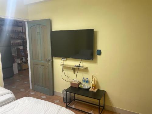 a bedroom with a tv on the wall and a table at See Hualien B&B in Hualien City