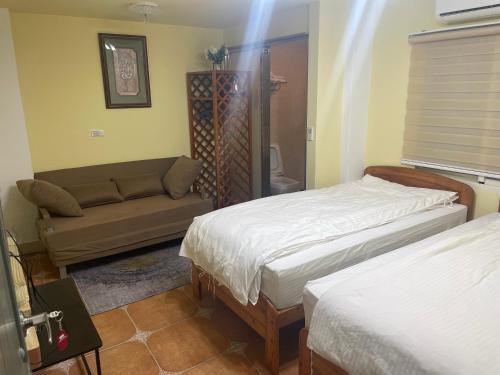 a living room with two beds and a couch at See Hualien B&B in Hualien City