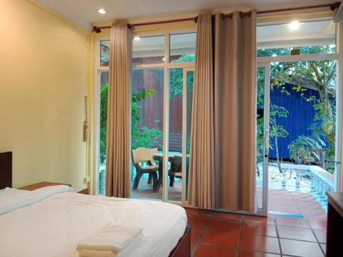 1 dormitorio con 1 cama y puerta corredera de cristal en Sok San Villa Koh Rong en Phumĭ Kaôh Rŏng