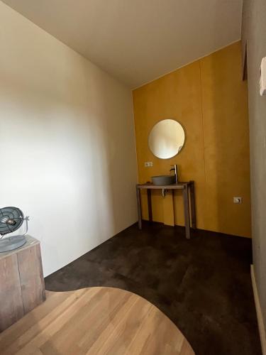 a small room with a table and a mirror at Hôtel En Tilleul in Pont-du-Navoy