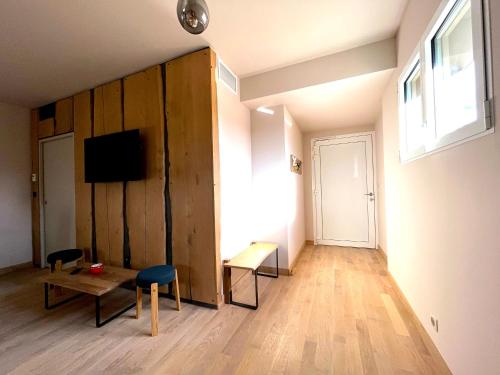 a living room with a tv and a table and chairs at Hôtel En Tilleul in Pont-du-Navoy