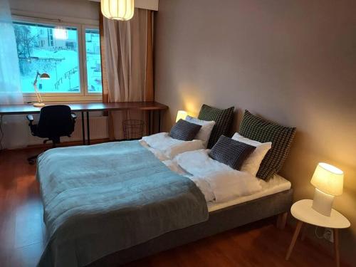 a bedroom with a bed with pillows and a desk at Cosy two rooms apartment in Helsinki in Helsinki