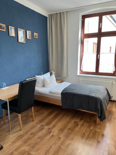 a bedroom with a bed and a table and a window at Alte Druckerei in Quedlinburg