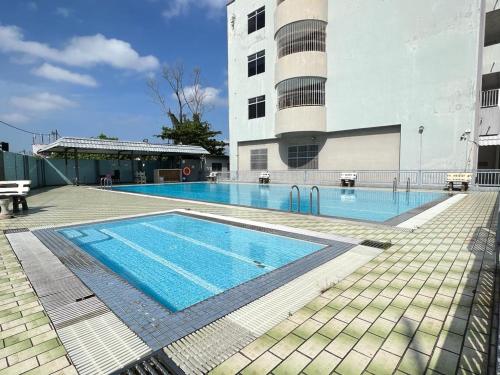 una gran piscina frente a un edificio en Batu Pahat Airbnb Homestay Empire 15 en Batu Pahat