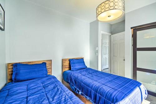 two beds in a room with blue sheets at Lakefront Bremerton Vacation Rental with Deck! in Bremerton