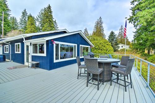 a blue tiny house with a table and chairs on a deck at Lakefront Bremerton Vacation Rental with Deck! in Bremerton