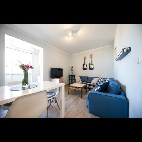 een woonkamer met een blauwe bank en een tafel bij Apartman Megi in Dubrovnik