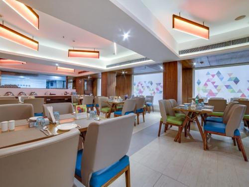 een eetkamer met tafels en stoelen in een restaurant bij ZIBE Hyderabad by GRT Hotels in Hyderabad