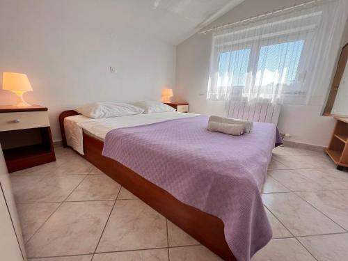 una camera da letto con un grande letto con una coperta viola di Family apartments with balcony D&A AE1590 a Vrsi (Verchè)