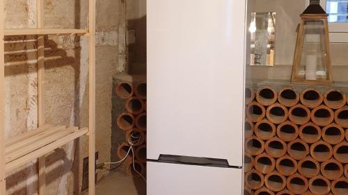 a room with a refrigerator and a shelf with pipes at Haus an sonniger Lage, schöner Blick auf Alpstein in Urnäsch